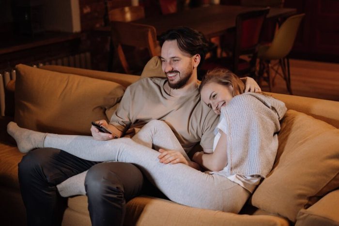 casal feliz no sofá ao saber o que é um flat