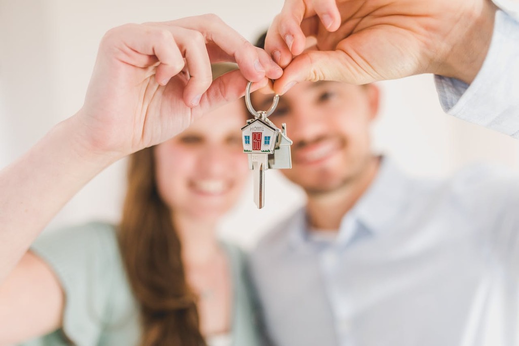 casal segurando chaves de imóveis após saber como financiar um apartamento